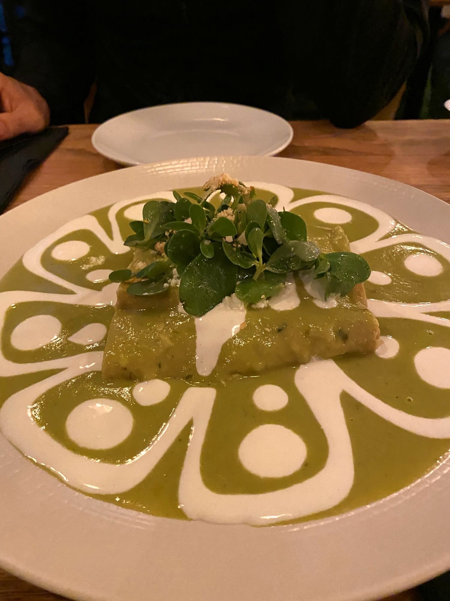 Enchiladas verdes topped with crema and greens at La Capital, a classic Mexican restaurant in Roma Norte, Mexico City