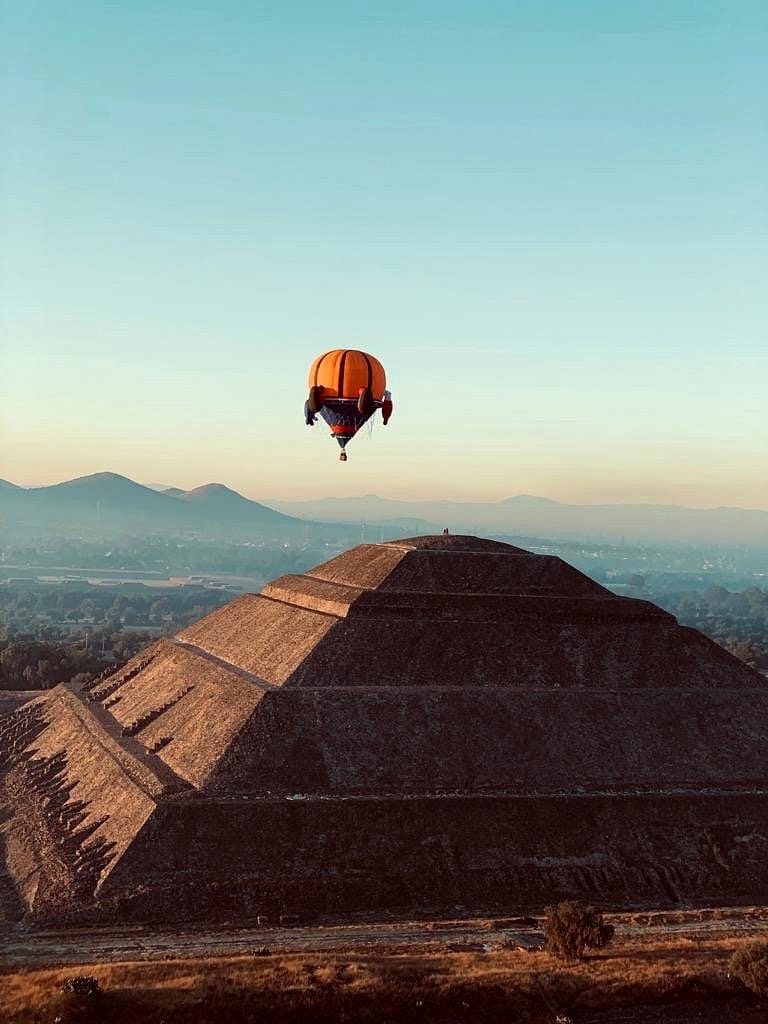 The Pyramid of the Sun at Teotihuacán at sunrise with a hot-air balloon overhead, a day trip from Mexico City
