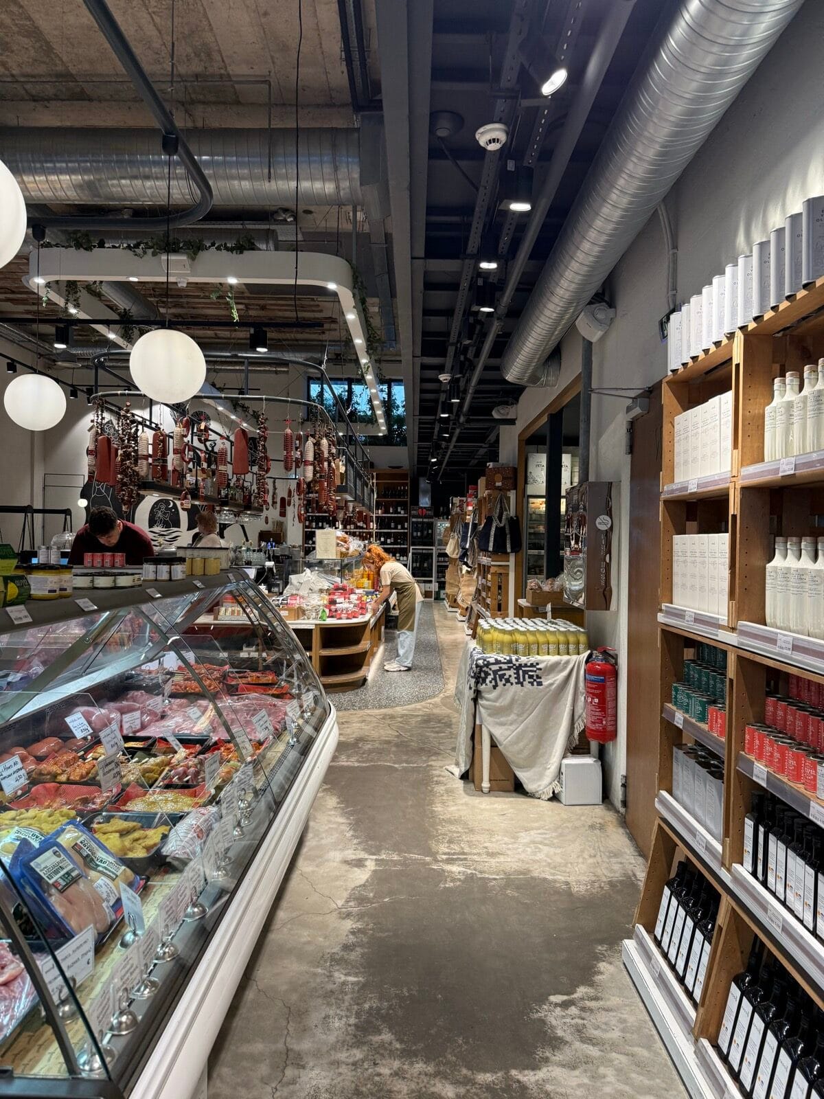Charcuterie, olive oil, and Greek pantry goods in the food market at Ergon House in Athens
